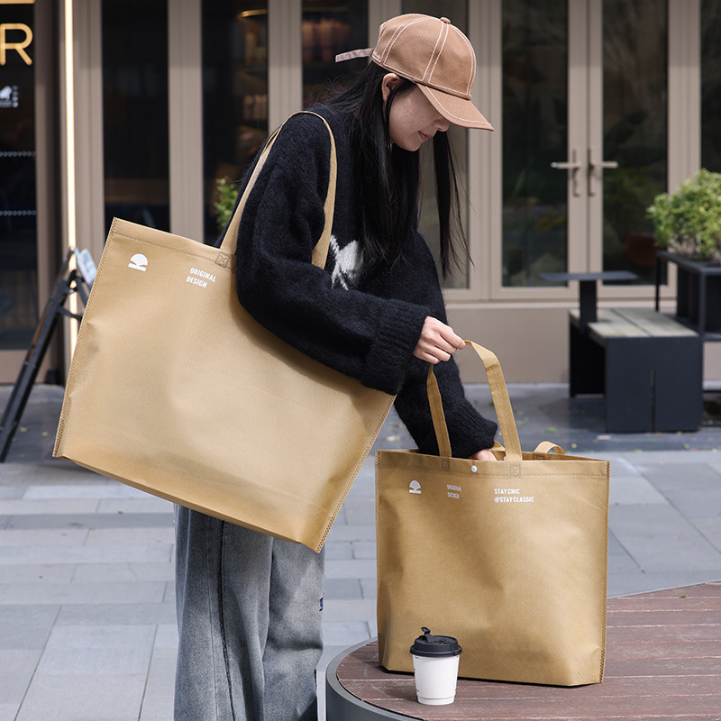 Bolso de mano no tejido de gran capacidad personalizado LOGO engrosado ropa de mujer protección ambiental bolsa de publicidad bolsa de compras de la tienda de ropa