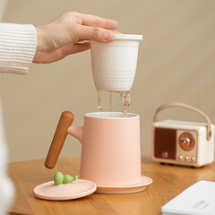 陶磁器の木の柄のマグカップは蓋を持ってお茶を濾過して分離します。