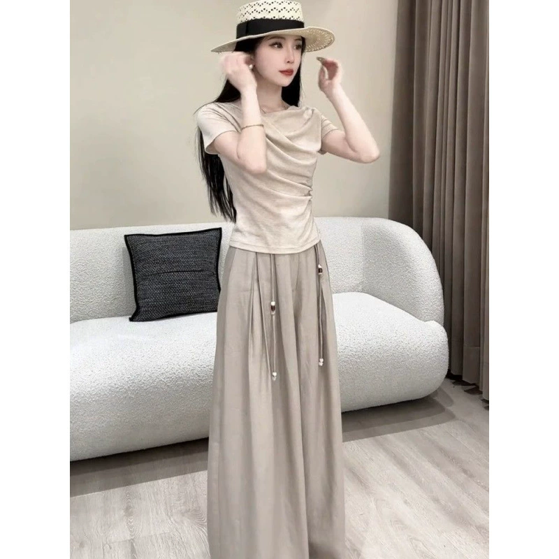 Летний костюм 2025 года в корейском стиле: топ с короткими рукавами и складками + широкие брюки с высокой талией, утягивающие фигуру.