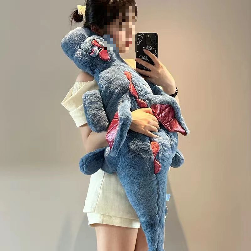 かわいい人形の小飛龍が寝ています。枕を抱いて恐竜のぬいぐるみを抱いて寝ます。|undefined