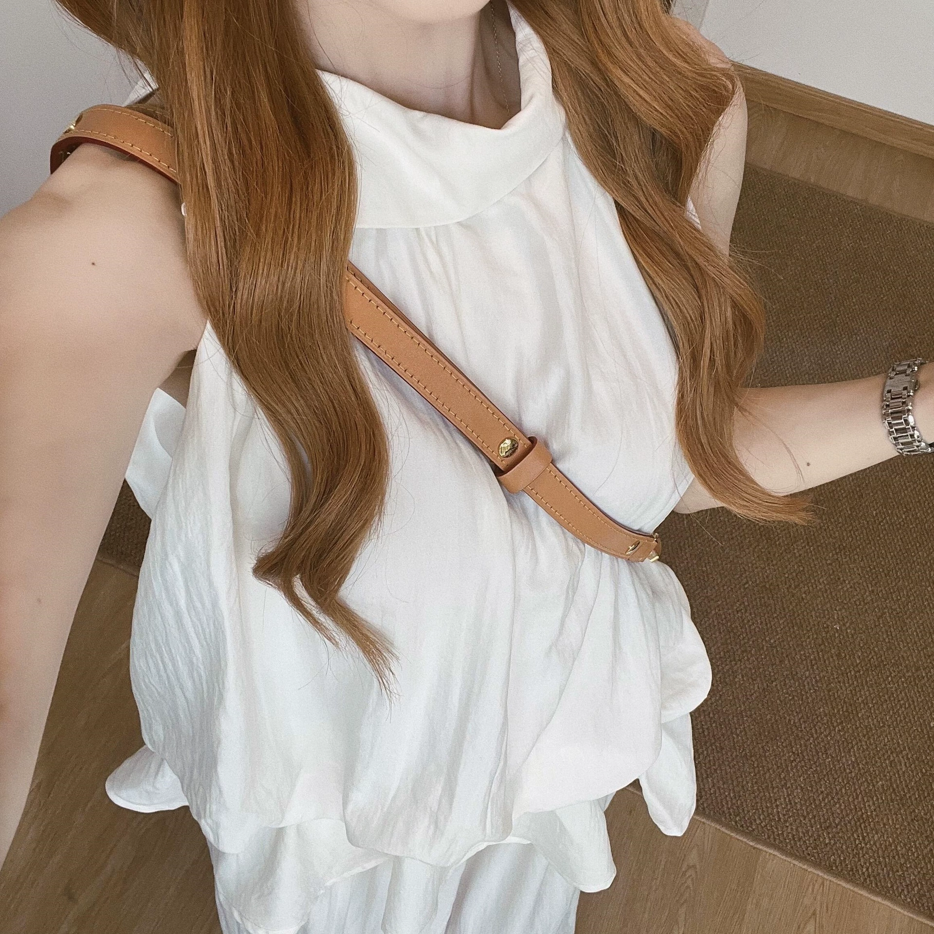 Летний комплект из двух предметов в корейском стиле 2025 года: топ-жилет с рюшами и завязками на шее и белые повседневные брюки.