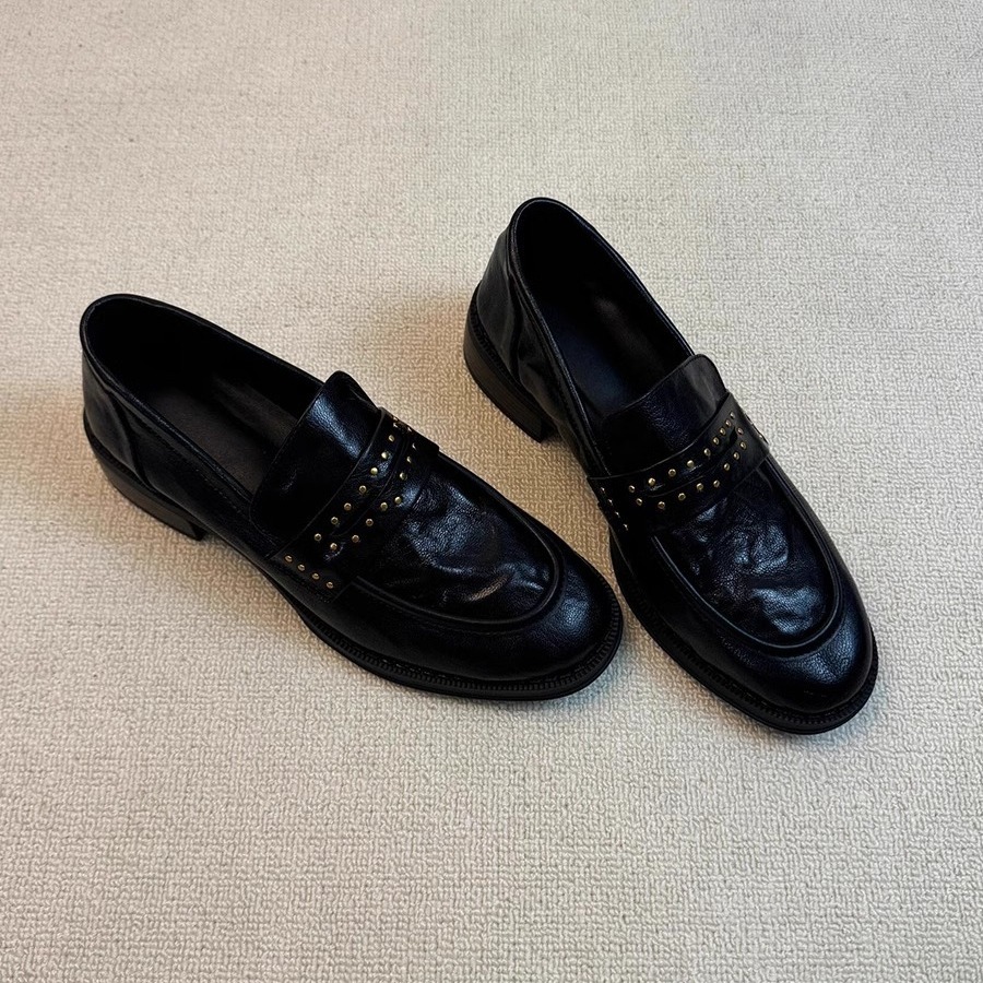 Versión de cuero de vaca de cuero retro estilo británico Remache de cabeza redonda plisado con un pie pedaleando zapatos de cuero negro gruesos zapatos de cuero para mujeres