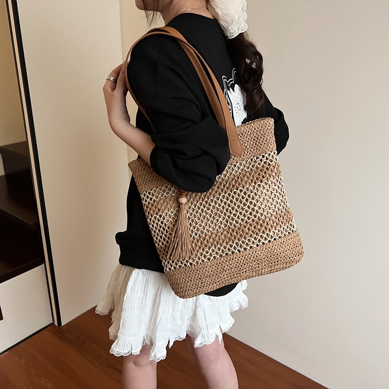 2025 nuevo bolso de cubo portátil de tendencia a cuadros, bolso de paja hueco de vacaciones junto al mar, bolso de hombro de playa de gran capacidad