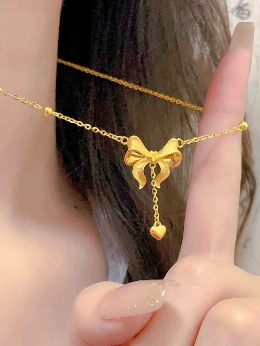 Collana con pendente a cuore e fiocco con nappe dorata_voghion.com