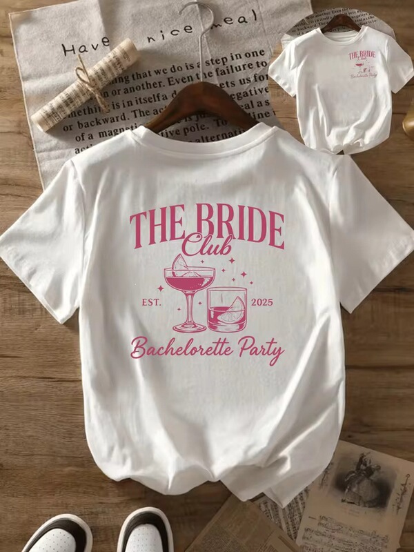 Women's "Bride's Club" graphic t-shirt in white with pink lettering and a wine glass design is perfect for spring Women's "Bride's Club" graphic t-shirt in white with pink lettering and a wine glass design is perfect for spring