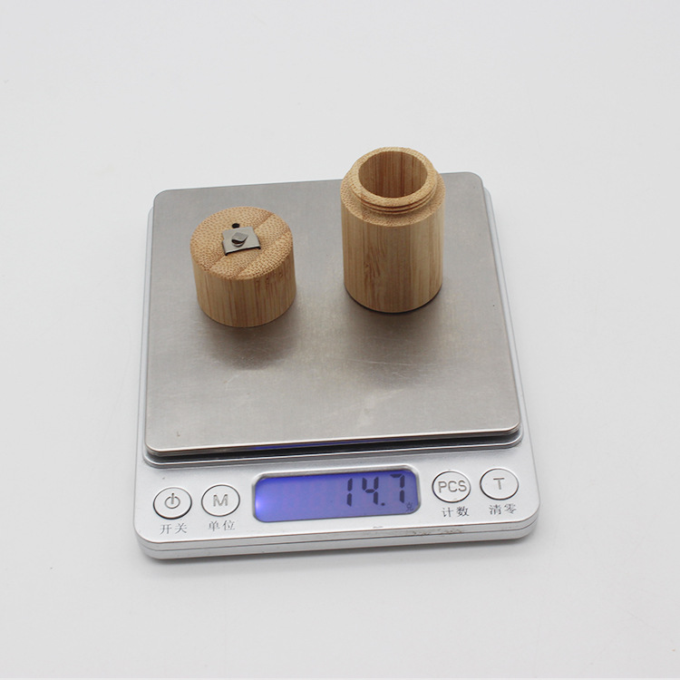 Light brown bamboo floss tube portable biodegradable case with a matching lid and a small metal clasp on the top.