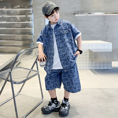 夏のデニムのスーツの男の子の薄いタイプの青少年のシャツの半袖の半ズボンの2つのセットの2025新型のファッションの子供服