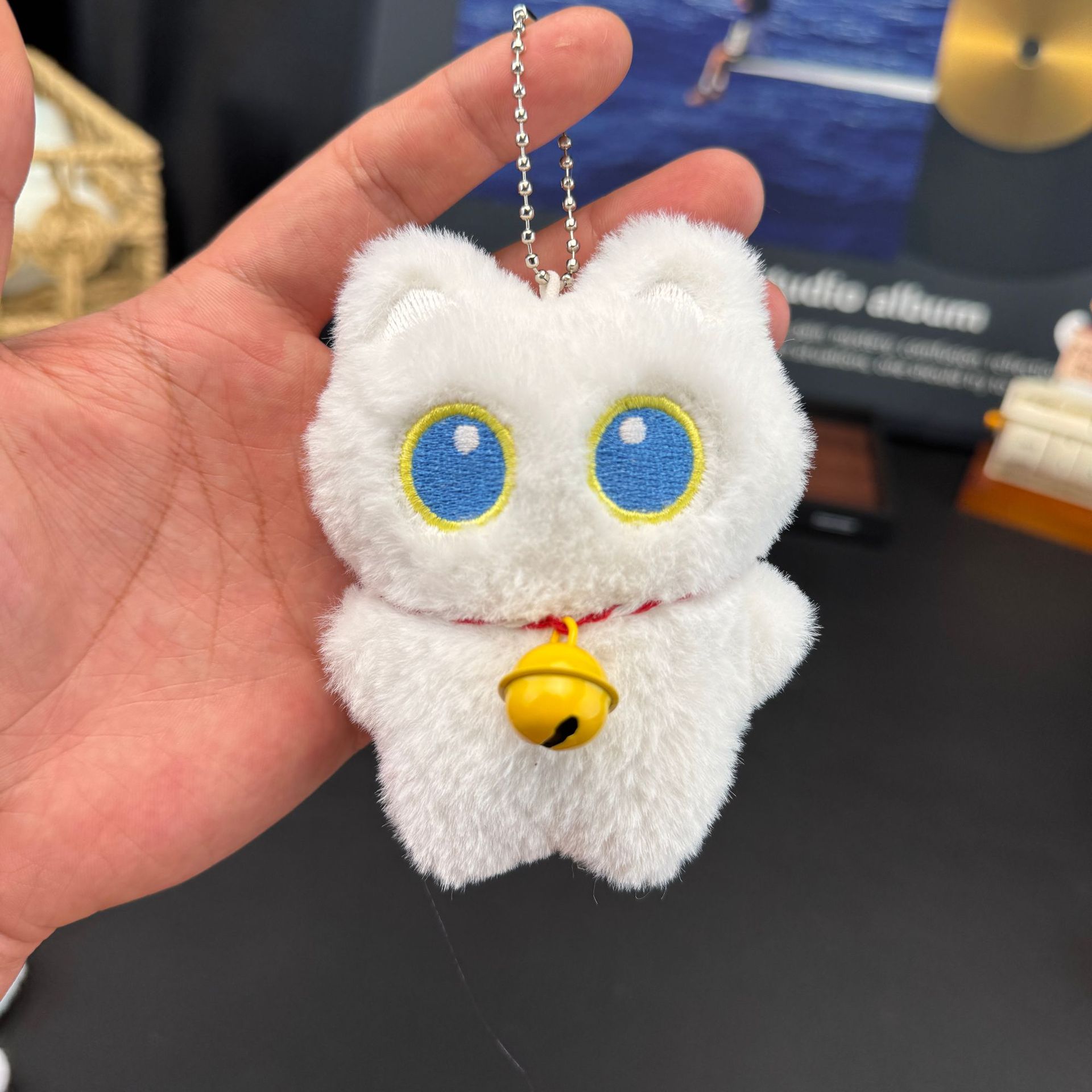 노란 종을 가진 흰 고양이