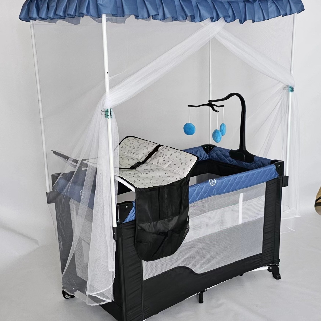 Cama de juegos para bebés con ruedas, mosquiteros de palacio con agujeros de juguete, mesa de pañales, estante de juguetes plegable