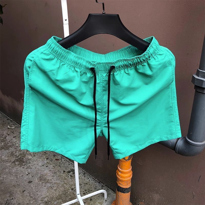 Pantalones de cuatro puntos Pantalones cortos casuales de verano para hombres Pantalones de playa de color caramelo para hombres de moda Pantalones de tres puntos deportivos sueltos de secado rápido