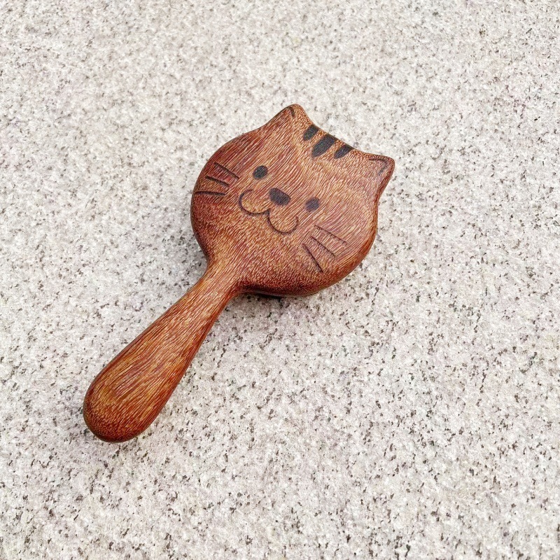 子猫は歯を挿して檀木のマッサージの櫛をします。|undefined