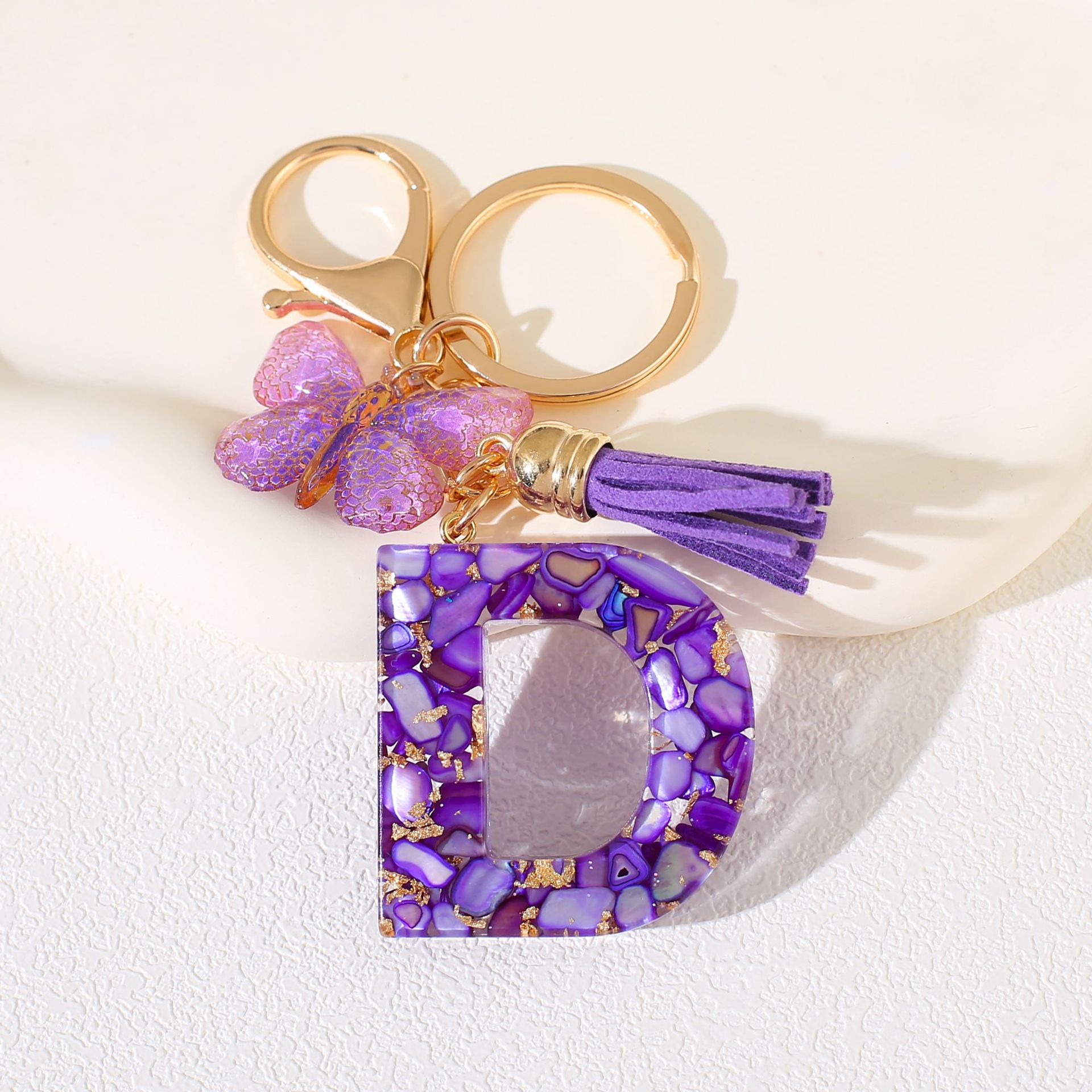 Fábrica directa de Yiwu accesorios de resina de goteo de embalaje llavero anillo de metal letras mariposa brilla colgante damas