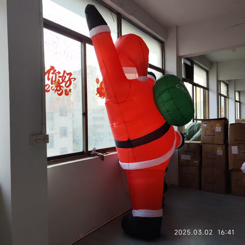 国境を越えた3メートルの壁に登るサンタクロースの空気型グリーンバックパッククリスマスの空気型老人の空気型|undefined