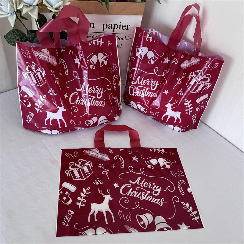 クリスマスの祝日の赤い厚手のプラスチックの贈り物の服の店は手提げの袋の包装で厚い買い物をして祝い事を包装します。|undefined