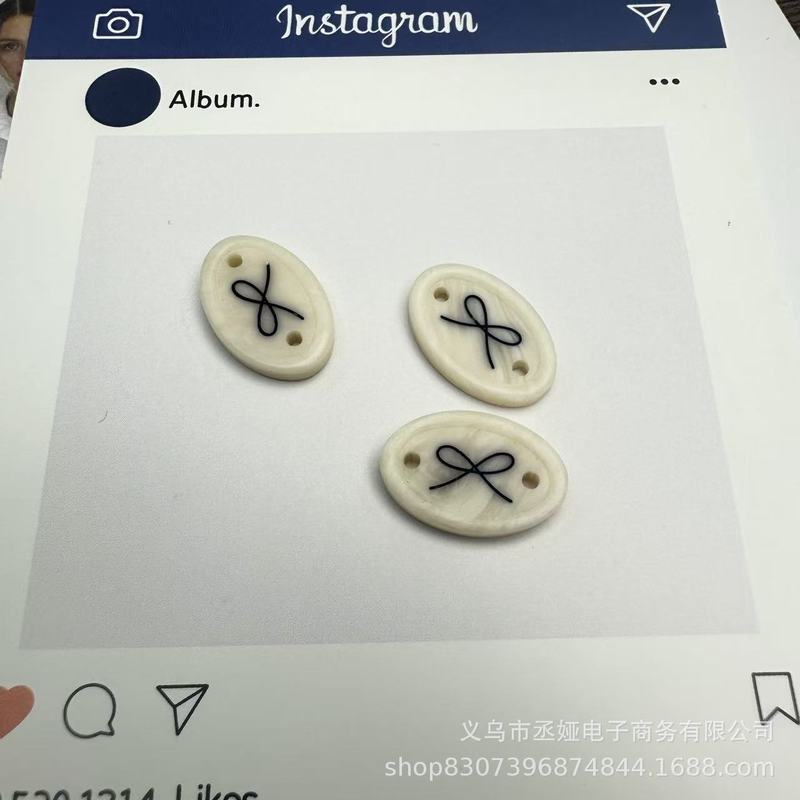现货仿贝树脂商标吊牌字母椭圆蝴蝶结衣标高端百搭装饰纽扣60款|undefined