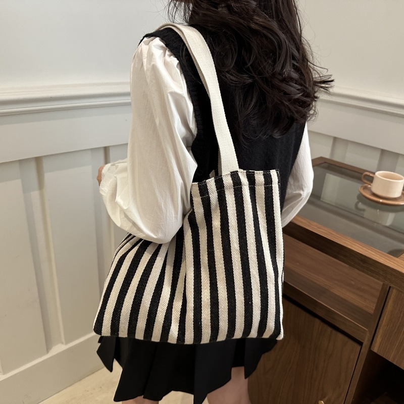 The new cross-border vertical striped commuter tote bag, hand-held shoulder bag, is fashionable and has a large capacity. It features an InS-style simple letter sail undefined