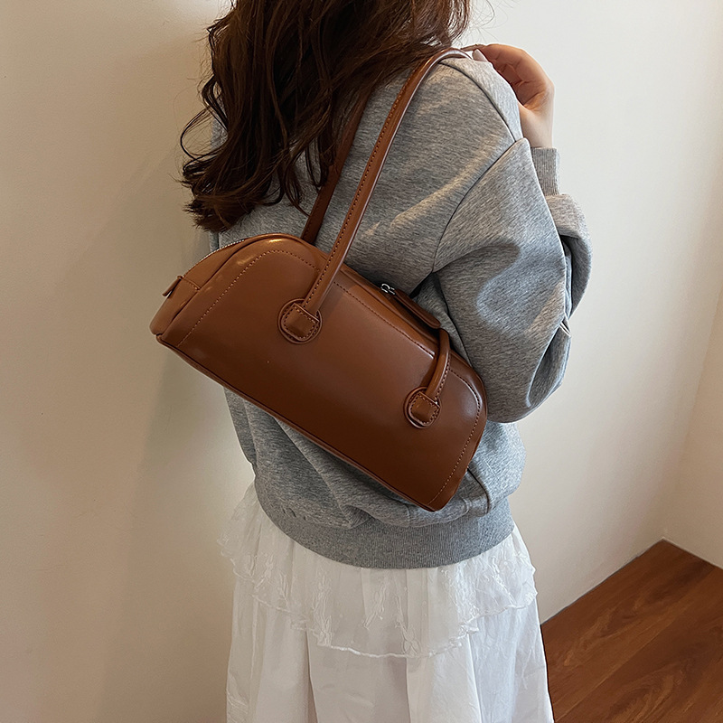 High-end nicho de moda bolso de hombro de mano para mujeres 2025 verano nuevo estilo simple bolso de viaje de palo bolso debajo de la axila