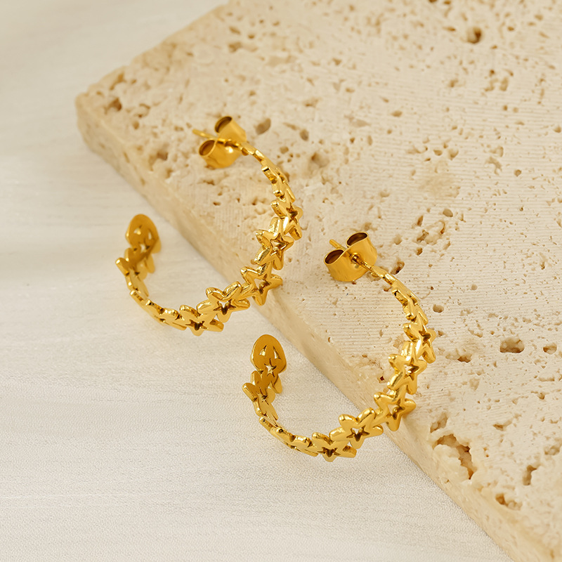 Nuevos pendientes de estrella de cinco puntas huecos de 18 quilates transfronterizos, diseño de nicho femenino, pendientes de personalidad de acero de titanio de moda simple al por mayor