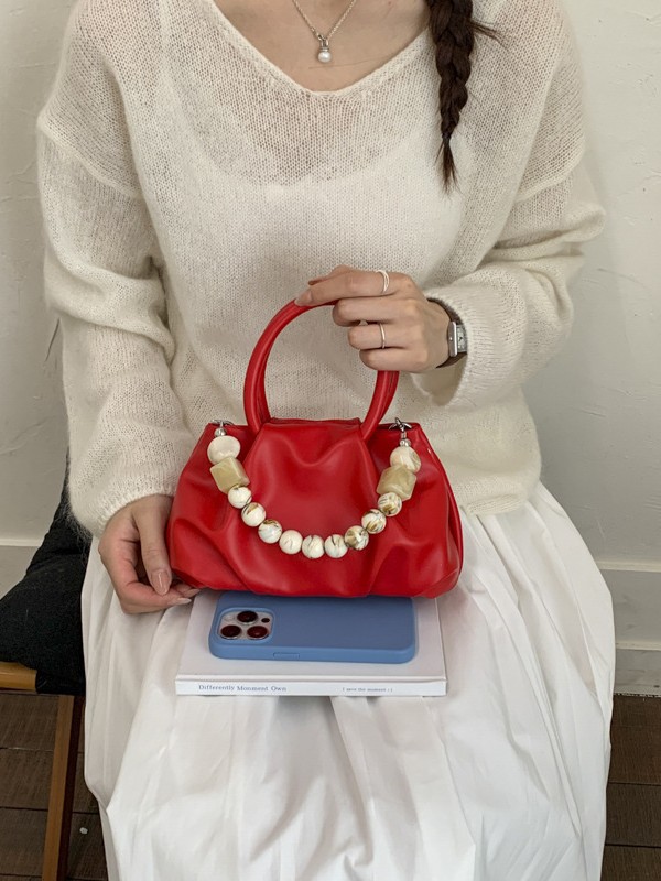 Alta sensación de mano pliegueada nube bolso de cubo para mujeres 2026 nuevo nicho de lujo ligero de moda perla bolsa de mochila