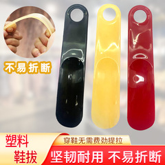 メーカーはプラスチック靴をまっすぐに持っています。子供は靴の神器を履いています。