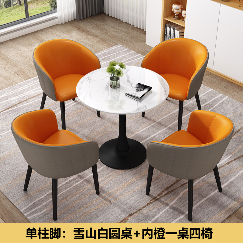 Montaña nevada, una columna blanca, una mesa naranja y cuatro sillas en el pie