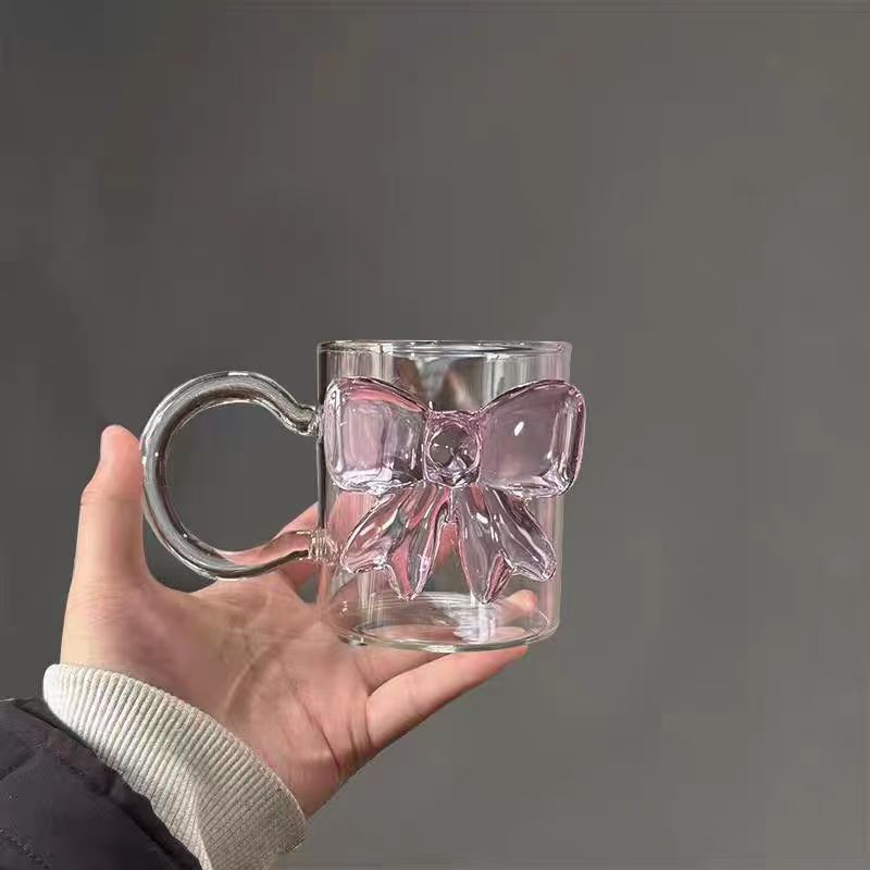 Bicchiere da caffè, succo, vino e cocktail rosa con fiocco, carino e di alta qualità._voghion.com