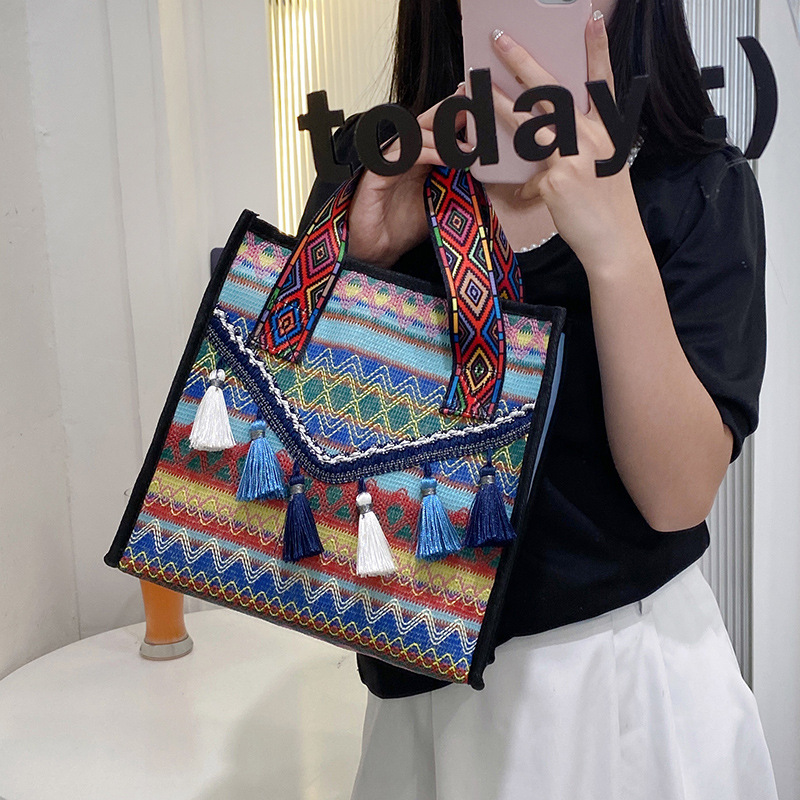 New hand-held fringed shopping bag 2022, fashionable ethnic style, Hong Kong style bucket bag, versatile woven bag for women full figure