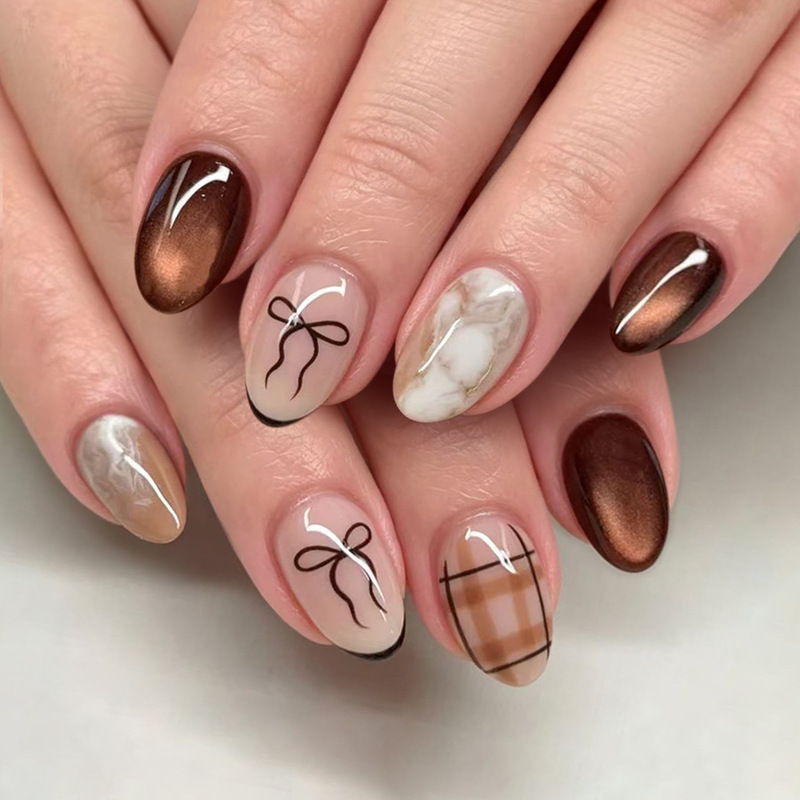 Short, glossy oval nails in European and American style for autumn and winter, brown cat-eye pattern with marble gradient and bow accents, 24-piece set Short, glossy oval nails in European and American style for autumn and winter, brown cat-eye pattern with marble gradient and bow accents, 24-piece set