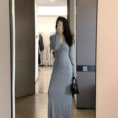 灰色の長袖のニットのワンピースの女性の春の気質は身を修めます。