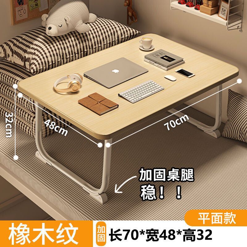 ベッドの上の小さい机のノートパソコンの机の上で折り畳みます。|undefined