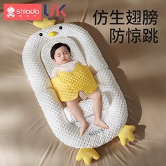 ベッドの中のベッドの赤ちゃんの新入生の赤ちゃんはびっくりしないでベッドの上の坂をなだめます。