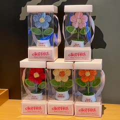 女神の日のプレゼントは手織りして毛糸の太陽の花の車に乗ってアイデアの贈り物のヒマワリの鉢植えを並べます。