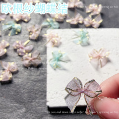 ネイルアクセサリーのネットの赤い爆発金の欧根紗の蝶結びのネイルアクセサリーのアイメイクの顔はネイルアクセサリーの古風な部品を貼ります。