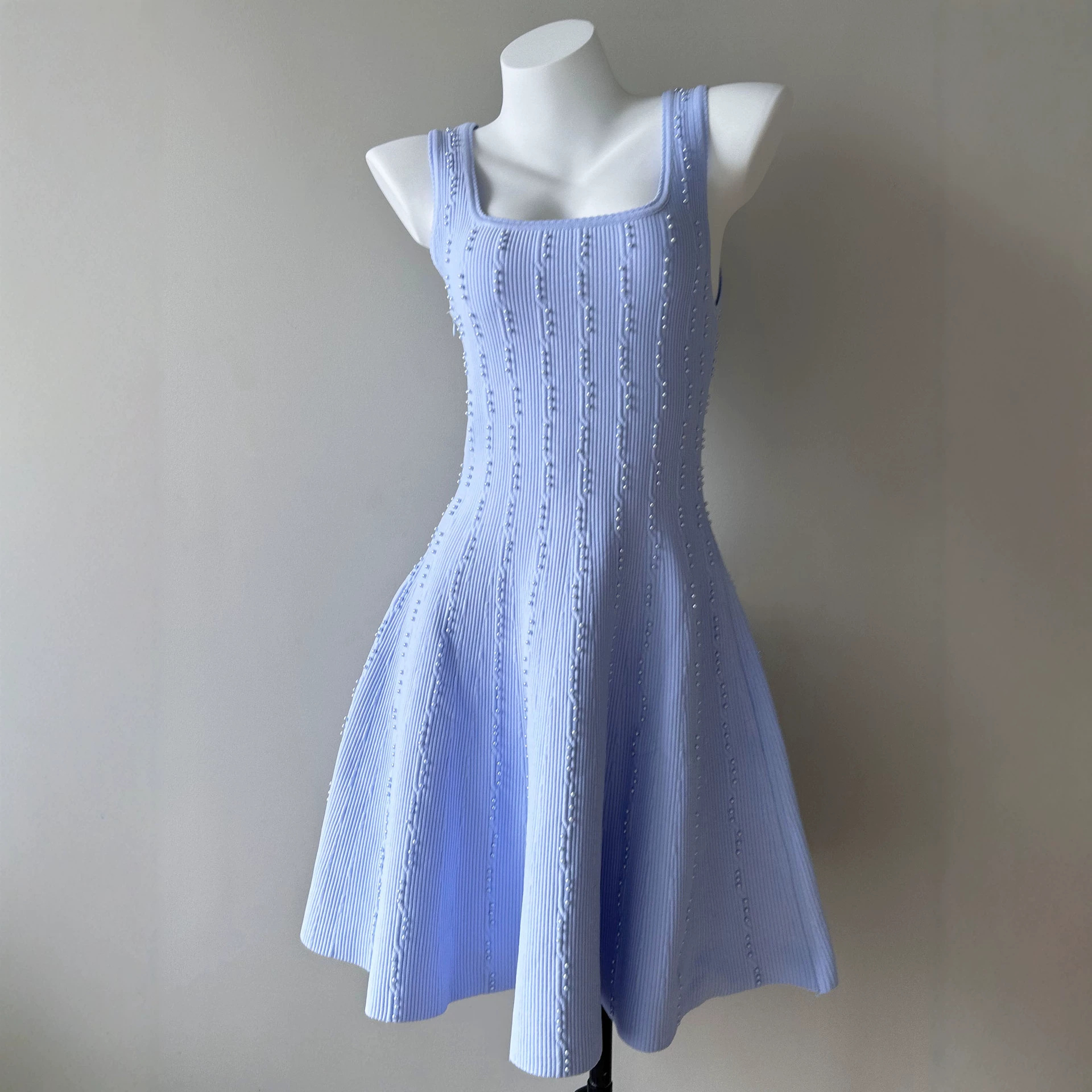 S-brand French-style sleeveless knitted heavily beaded A-line dress with a cinched waist for a slimming effect.