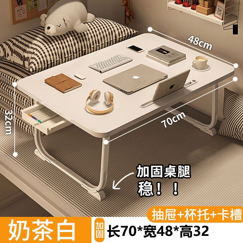 ベッドの上の小さい机のノートパソコンの机の上で折り畳みます。|undefined