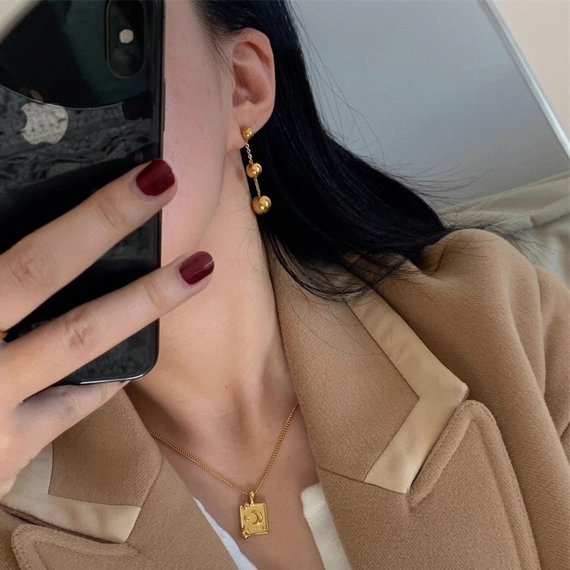 Close-up of Gold Titanium Steel Solid Ball Stud Earrings