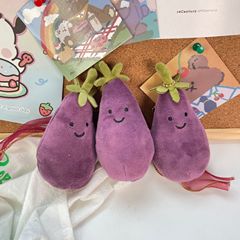 かわいい超萌えナスのほほえみ野菜の表情はぬいぐるみの息子の包みのペンダントのゲーム城を包んで子供のプレゼントをつかみます。