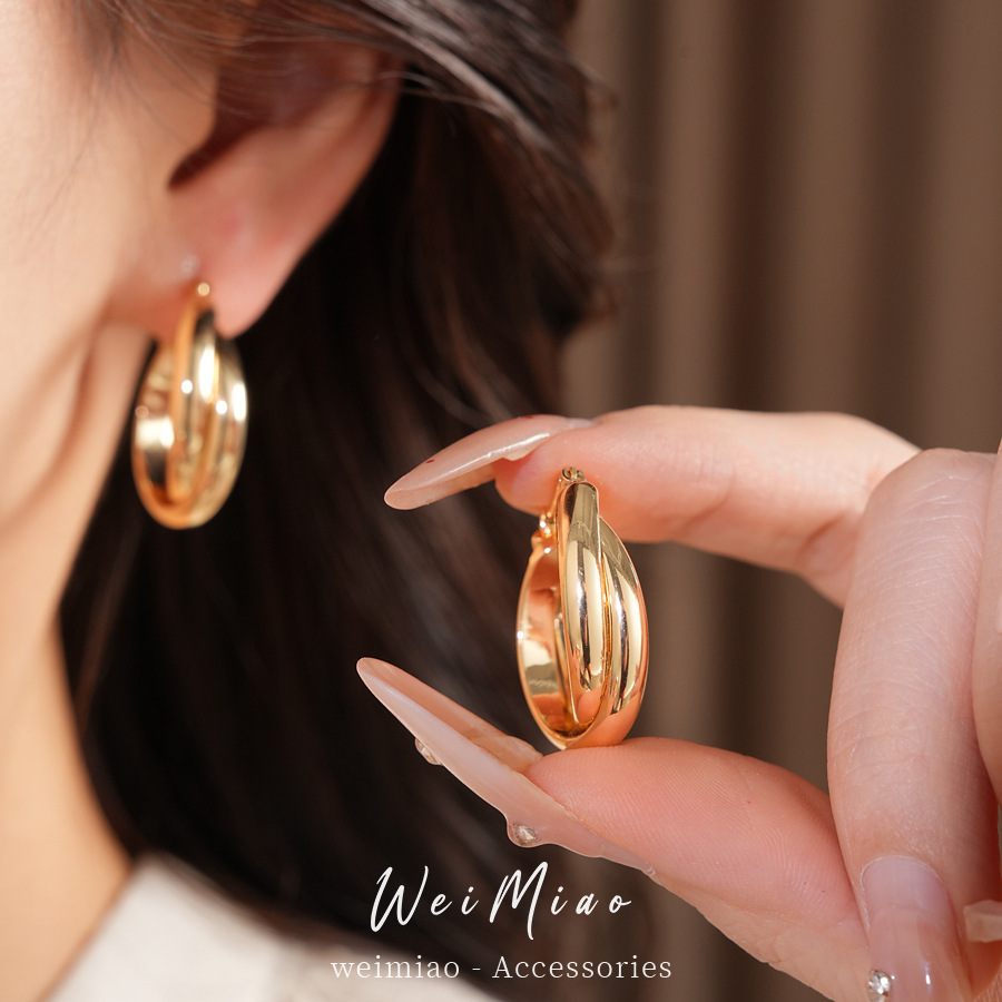 Brillante redondo enrollado cruzado perfiles temperamento simple personalidad aretes ligeros de lujo alta sensación auriculares al por mayor mujeres