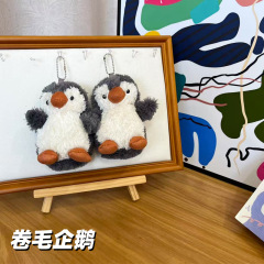 Ins風巻き毛小ペンギンのぬいぐるみがピーナッツペンギンのキーホルダーを飾っています。
