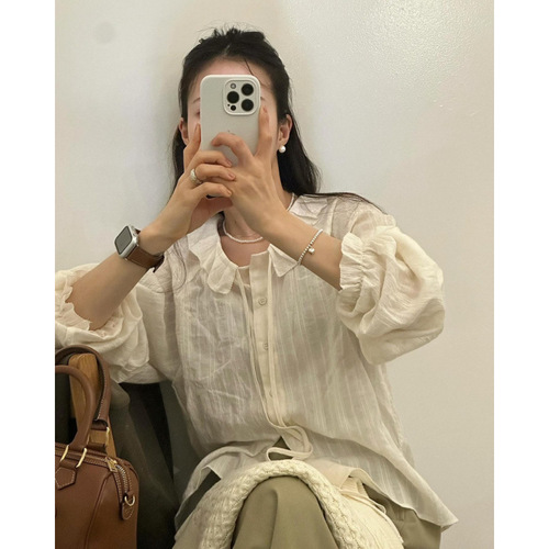 White long-sleeved shirt with floral lace and ribbon details, featuring a sweet chic early autumn vibe, paired with a knitted cabled vest.