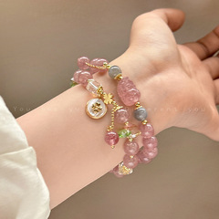 桃の花のいちごの結晶のピンクの数珠のブレスレットの女性を招きます。