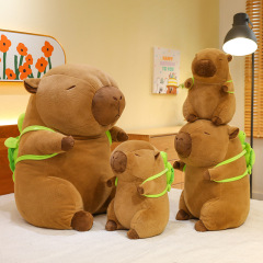 ネットの赤いカピバラのぬいぐるみは鼻の水豚の子供がぼうっとしています。リュックサックの大きいサイズのカメの水豚は枕を抱いています。