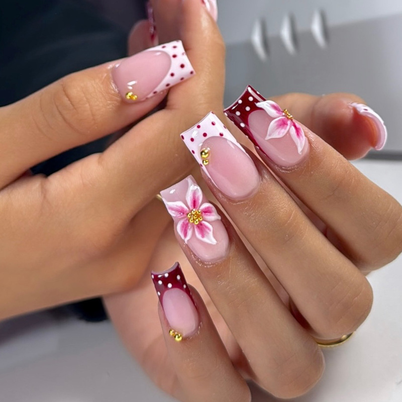 Wearable nails with medium-length rectangular white polka dots, French-style edges, 3D three-dimensional flowers, and gold steel bead embellishments Wearable nails with medium-length rectangular white polka dots, French-style edges, 3D three-dimensional flowers, and gold steel bead embellishments