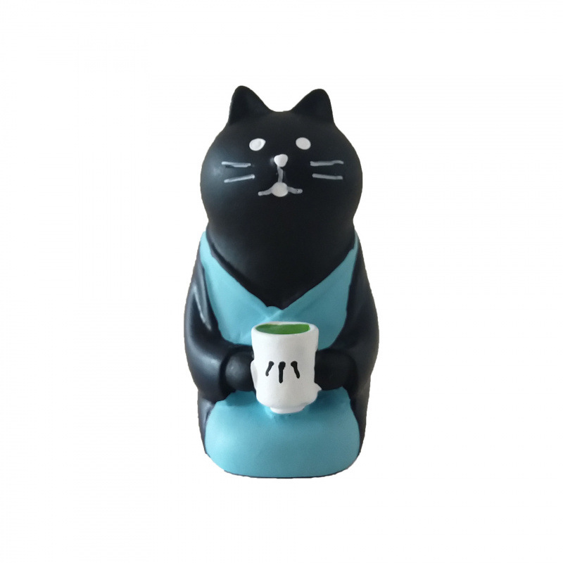 무릎을 꿇고 차를 마시는 검은 고양이