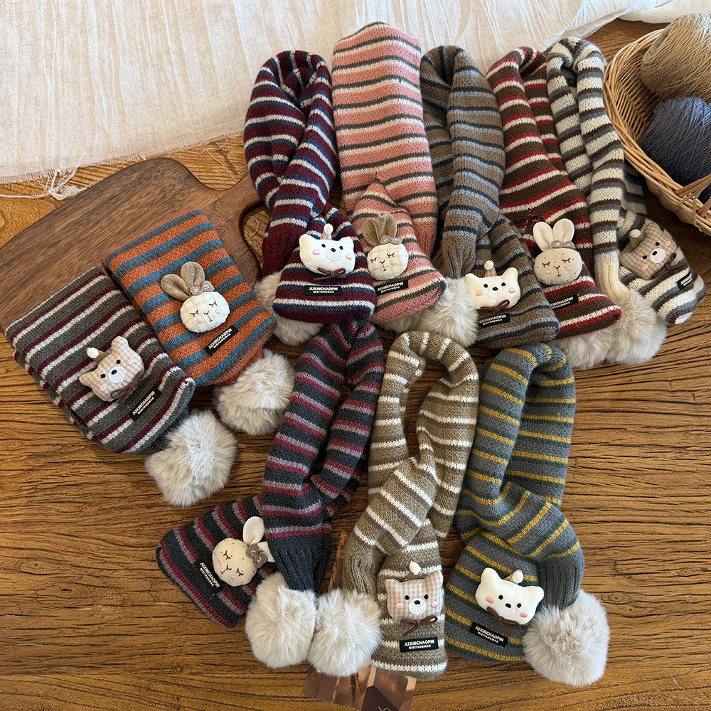 Trendy Korean-style children's scarf for winter, featuring contrasting colors and pom-poms, suitable for both boys and girls, and designed for outdoor warmth with a crossover design