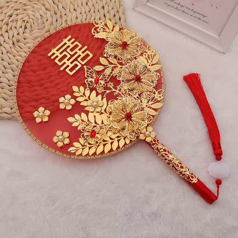 中国式の結婚式の秀禾の顔の団扇の震え音の赤い本の新婦の結婚する手は花の古風をささげて結婚します。|undefined