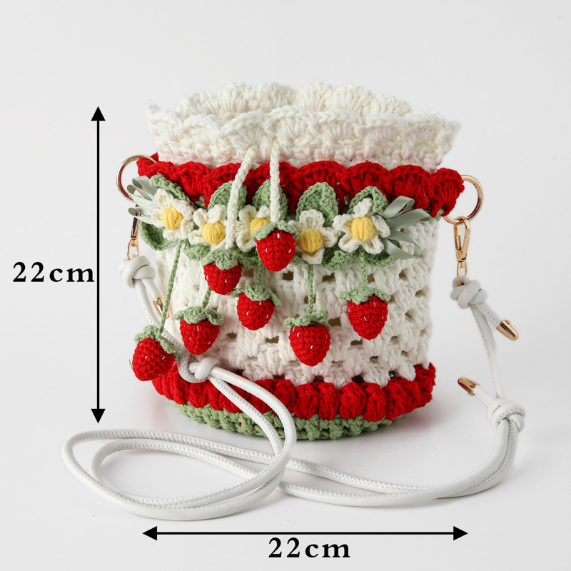 ネットの赤いタイプの編み物の手作りのスカーフのバケツの包みのセットのイチゴのケーキのすずらんの花束の包みはイチゴのバケツを抱いています。|undefined