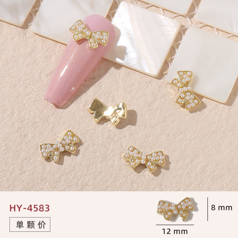 Uñas mariposa joyería nueva línea popular perla arco metal decoración de uñas pequeños accesorios de joyería al por mayor