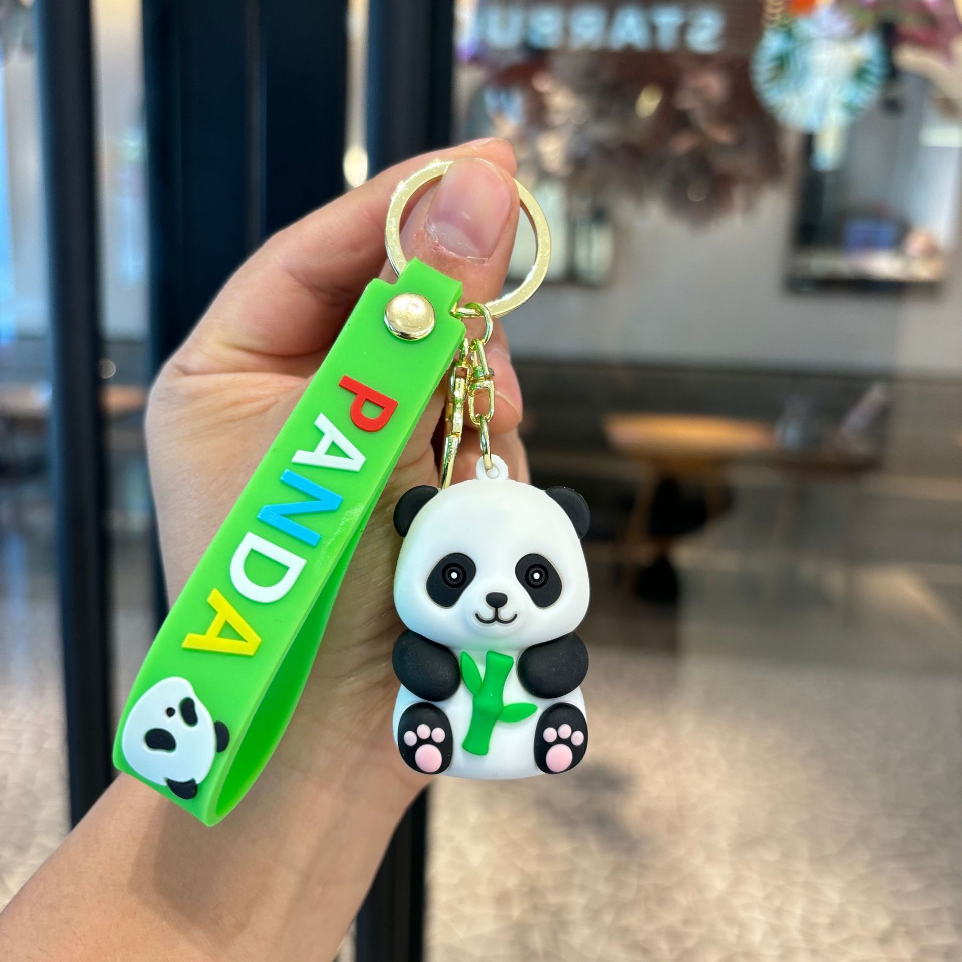 アニメは竹のパンダのキーホルダーを抱いてかわいいパンダのカップルの小銭入れを掛けます。