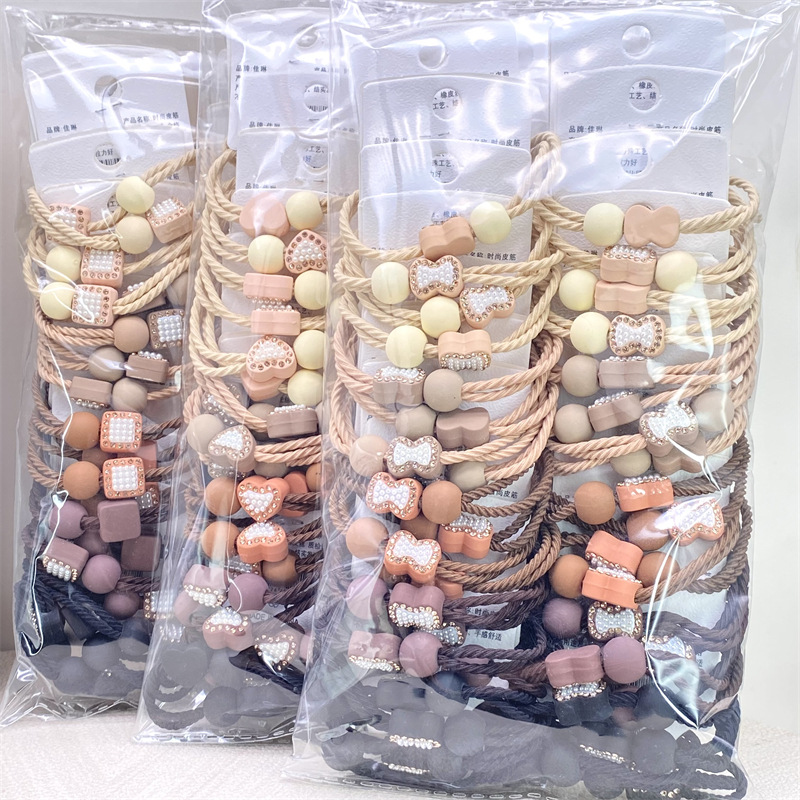 Etiqueta de estilo coreano accesorios para el cabello para niños Perla pequeña pajarita cuerda de pelo chica estudiante cabeza cuerda banda de goma dos yuanes suministro de la tienda